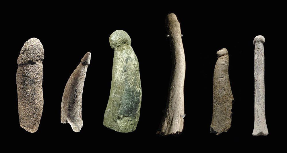 12,000 BCE. Several stone phallic objects, some featuring piercings, scars, and tattoos.